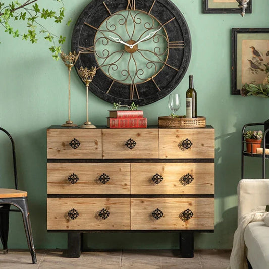Wooden dresser with decorative clock against a green wall