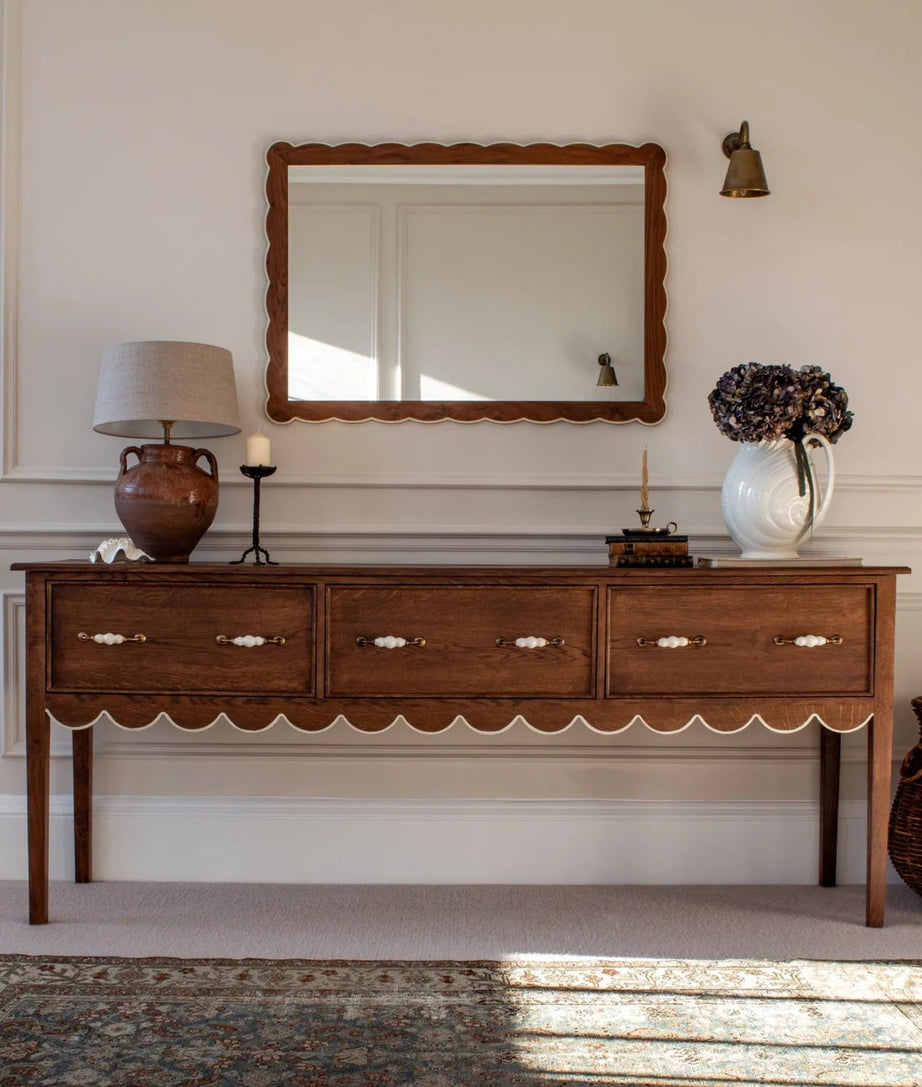 Wooden console table with decorative items against a wall