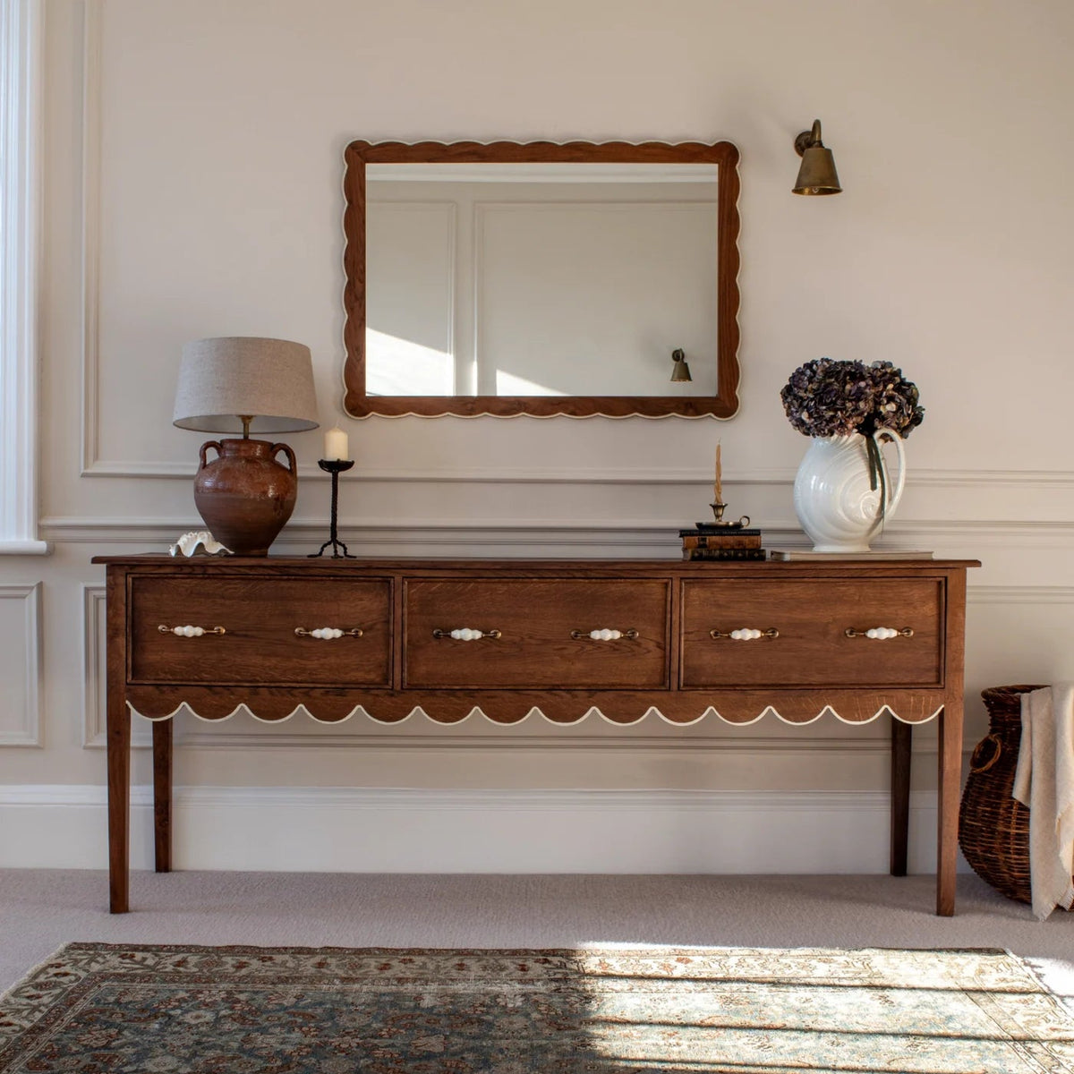 Wooden console table with decorative items against a wall